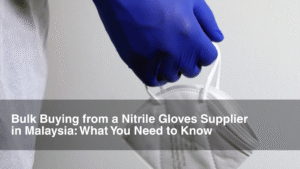 Doctor in PPE equipment and blue nitrile gloves holds up mask